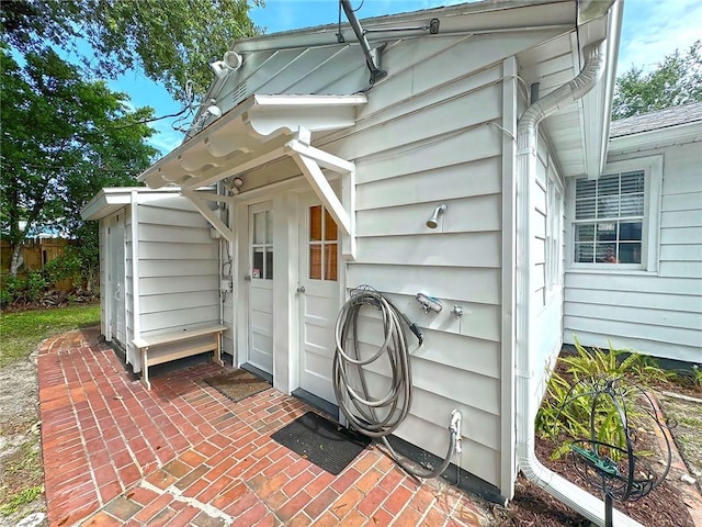 view of exterior entry with a patio area