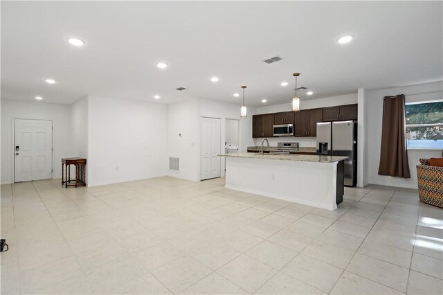 8646 102nd Ave, Vero Beach, FL 32967 - kitchen with stainless steel appliances, dark brown cabinets, an island with sink, a sink, and recessed lighting