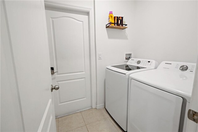 8646 102nd Ave, Vero Beach, FL 32967 - laundry room featuring washing machine and clothes dryer, light tile patterned floors, and baseboards