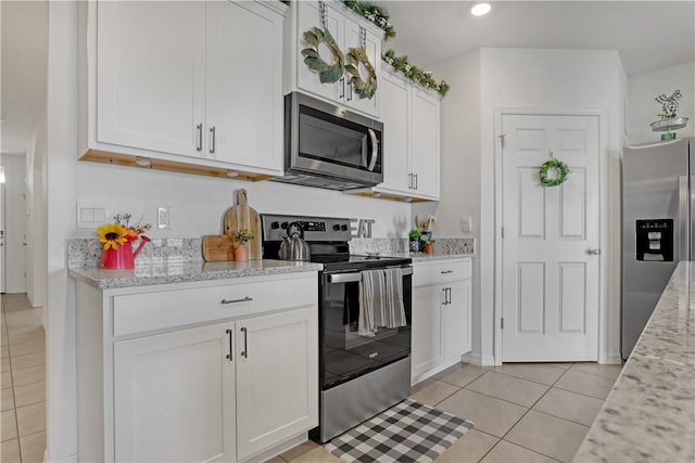 kitchen featuring appliances with stainless steel finishes, light stone countertops, and white cabinets