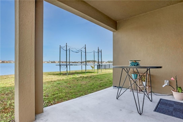 view of patio featuring a trampoline and a water view