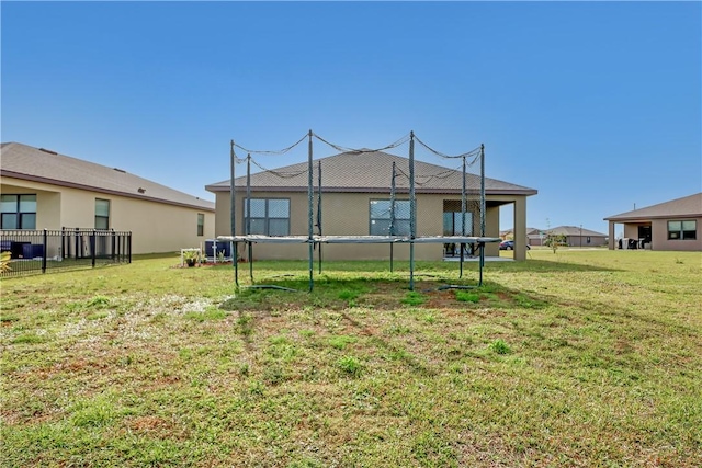 rear view of house with a yard and central AC