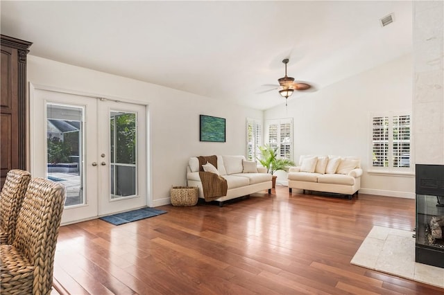 living room with hardwood / wood-style floors, vaulted ceiling, ceiling fan, and french doors