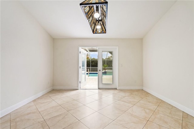 empty room with light tile patterned flooring and french doors