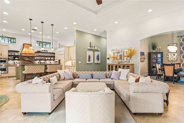 tiled living room with ornamental molding and ceiling fan