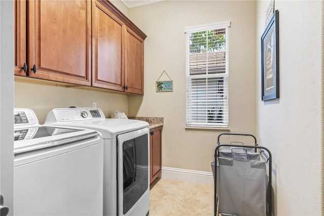 washroom featuring light tile patterned flooring, cabinet space, baseboards, and washer and clothes dryer