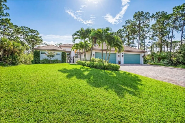 view of front of property featuring a garage, stucco siding, decorative driveway, and a front lawn