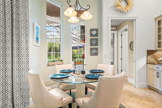 dining room featuring light tile patterned floors, baseboards, and a chandelier