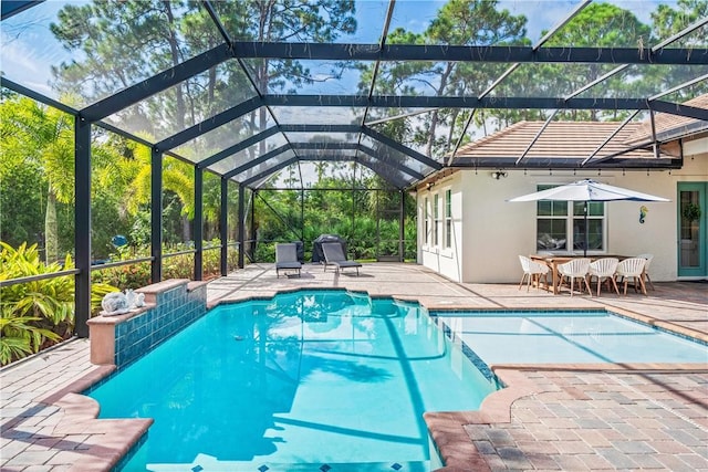 pool with a patio area and glass enclosure