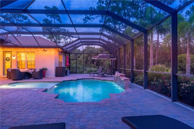 pool featuring glass enclosure and a patio