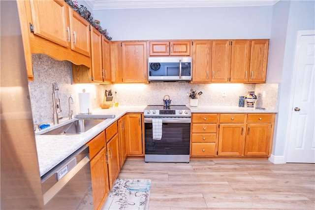 kitchen featuring decorative backsplash, stainless steel appliances, light hardwood / wood-style floors, and sink