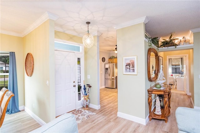 foyer with light wood-type flooring, ceiling fan, and ornamental molding