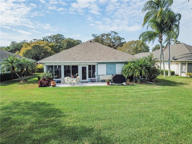 back of house with a lawn, a sunroom, and a patio area