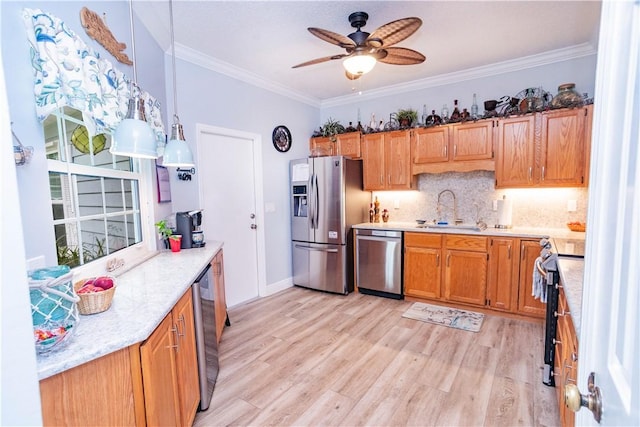kitchen featuring a sink, crown molding, light wood-style floors, and appliances with stainless steel finishes