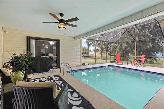 view of swimming pool with a patio, glass enclosure, and ceiling fan