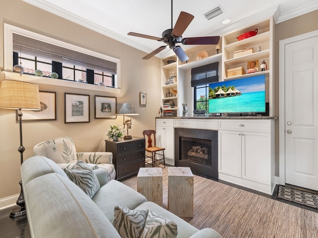 living room with ornamental molding, built in features, ceiling fan, and dark hardwood / wood-style flooring