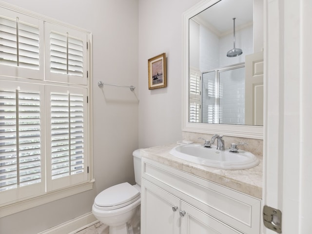 bathroom featuring ornamental molding, vanity, toilet, and a shower with door