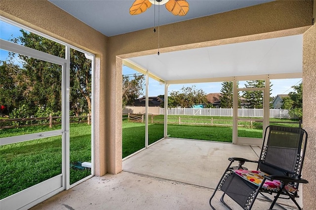 unfurnished sunroom with ceiling fan