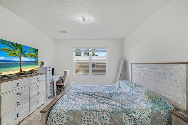 bedroom with a textured ceiling and carpet flooring