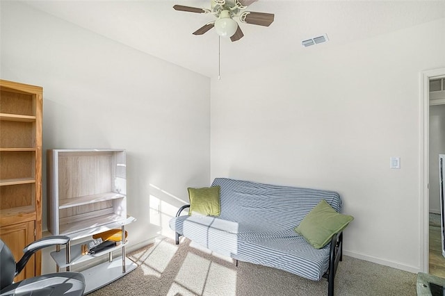 living area with ceiling fan and carpet flooring