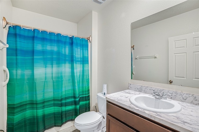 bathroom with vanity, a textured ceiling, and toilet