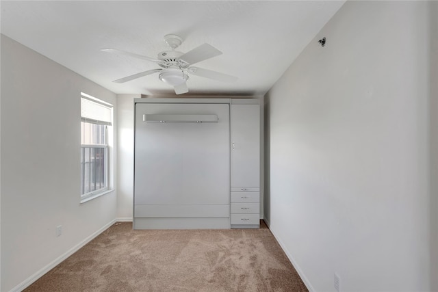 unfurnished bedroom featuring a closet, light colored carpet, and ceiling fan