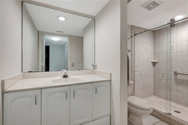 bathroom featuring toilet, vanity, tile patterned flooring, and walk in shower