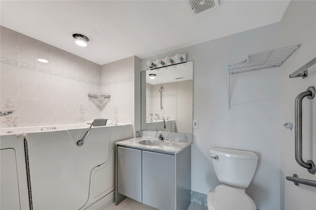 bathroom with toilet, vanity, and tile patterned floors