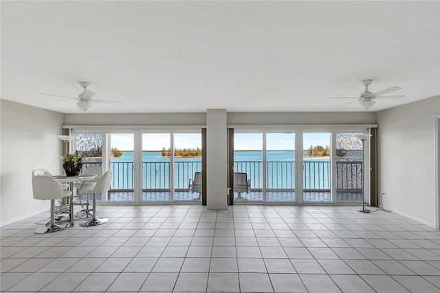 interior space with ceiling fan, a healthy amount of sunlight, and a water view