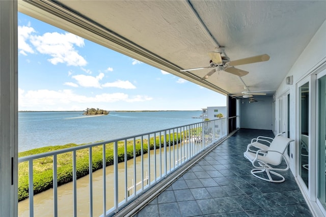 balcony featuring a water view and ceiling fan