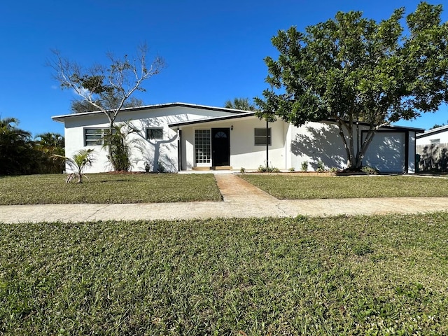 ranch-style house featuring a garage and a front lawn