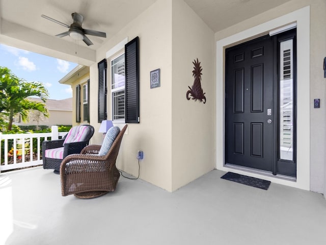 view of exterior entry with a porch and ceiling fan