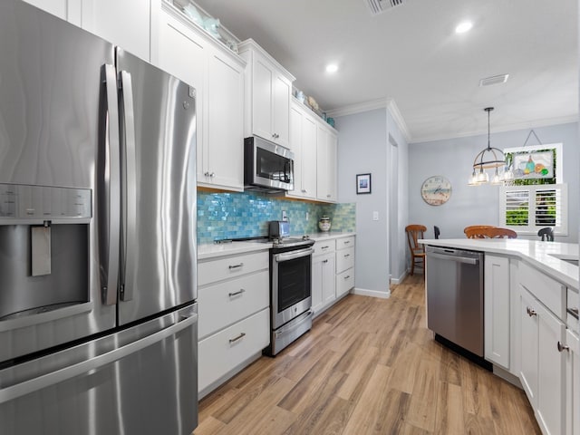 kitchen with light hardwood / wood-style flooring, a chandelier, crown molding, white cabinetry, and appliances with stainless steel finishes