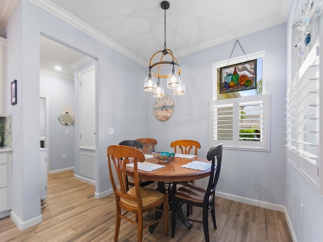 dining room featuring light hardwood / wood-style floors and crown molding