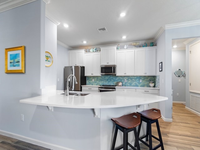 kitchen featuring white cabinetry, light hardwood / wood-style floors, appliances with stainless steel finishes, and sink