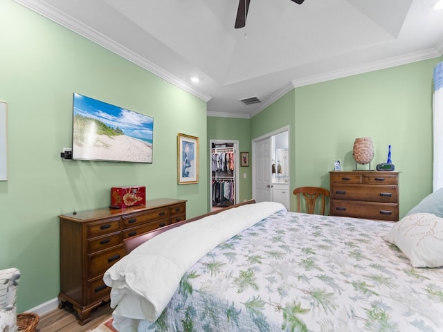 bedroom featuring ornamental molding, ensuite bathroom, ceiling fan, a spacious closet, and a closet