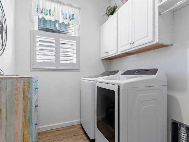 laundry room featuring light hardwood / wood-style floors, cabinets, and washing machine and clothes dryer