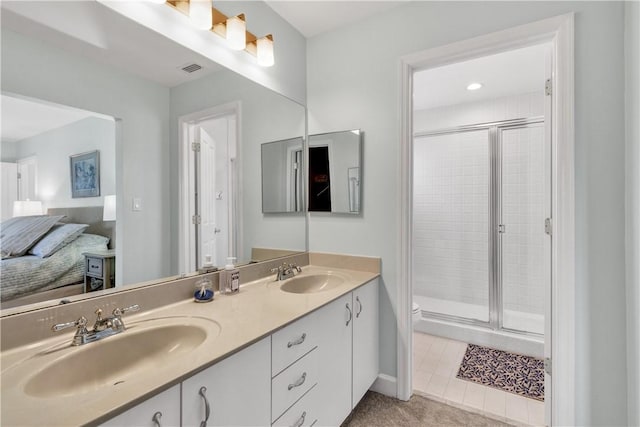 ensuite bathroom with double vanity, a sink, visible vents, and a shower stall