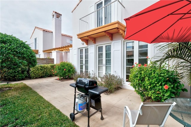 view of patio with grilling area and a balcony