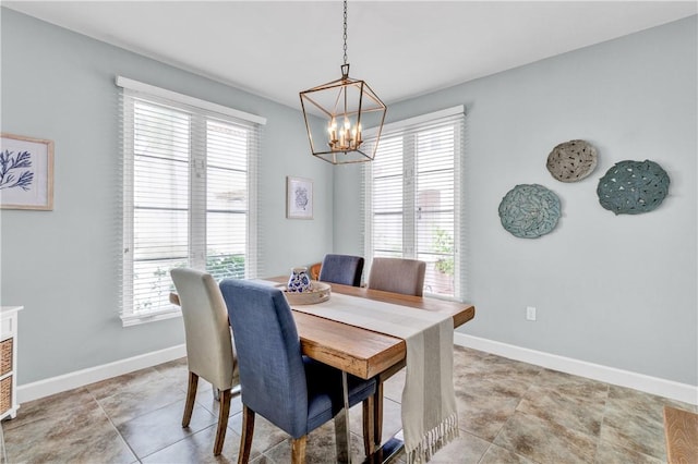 dining room featuring baseboards and a notable chandelier