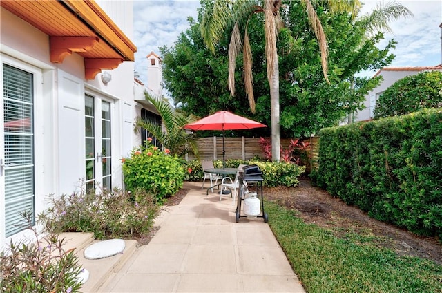 view of patio featuring french doors and fence