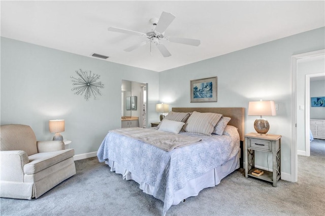 carpeted bedroom featuring visible vents, ceiling fan, ensuite bath, and baseboards