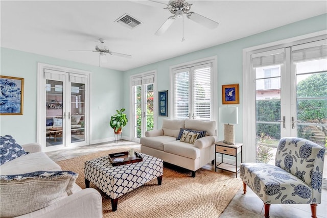 living room with a ceiling fan, french doors, visible vents, and baseboards