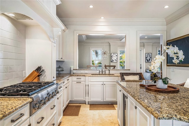 kitchen with stone counters, white cabinets, sink, tasteful backsplash, and stainless steel gas cooktop