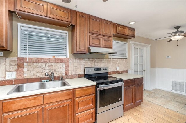 1751 5th Ct, Vero Beach, FL 32960 - kitchen featuring electric range, a ceiling fan, under cabinet range hood, a sink, and wainscoting