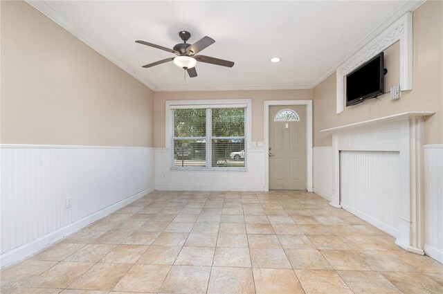 1751 5th Ct, Vero Beach, FL 32960 - unfurnished living room featuring ceiling fan, a wainscoted wall, crown molding, and light tile patterned flooring