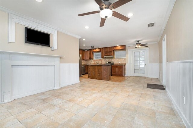 1751 5th Ct, Vero Beach, FL 32960 - kitchen featuring open floor plan, ceiling fan, ornamental molding, brown cabinetry, and a center island
