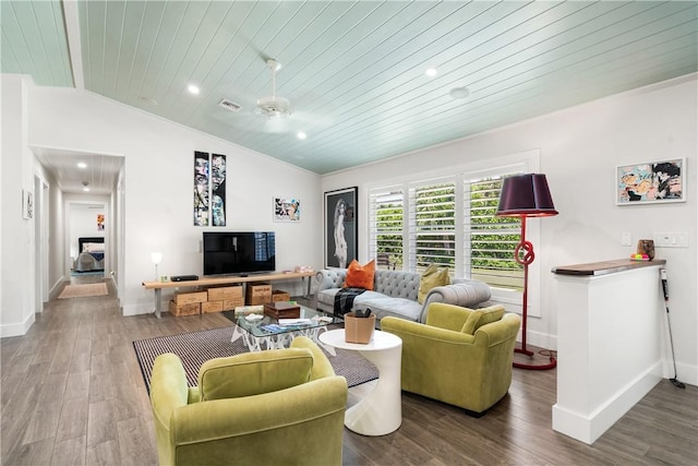 living room featuring baseboards, visible vents, vaulted ceiling, and wood finished floors