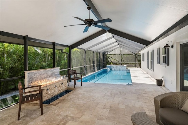 view of swimming pool with a patio area, a pool with connected hot tub, glass enclosure, and a ceiling fan