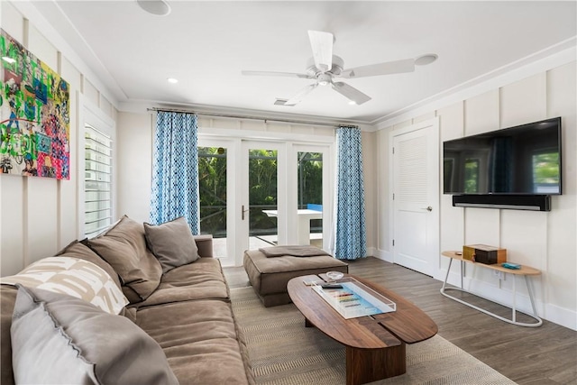 living area with crown molding, visible vents, a ceiling fan, wood finished floors, and baseboards